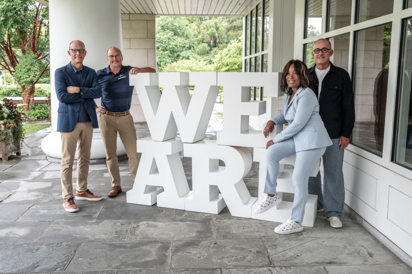 photo of alumni guests on The CMO Podcast posing with large white We Are letters during ALC 2025, photo by Penn State Alumni Association
