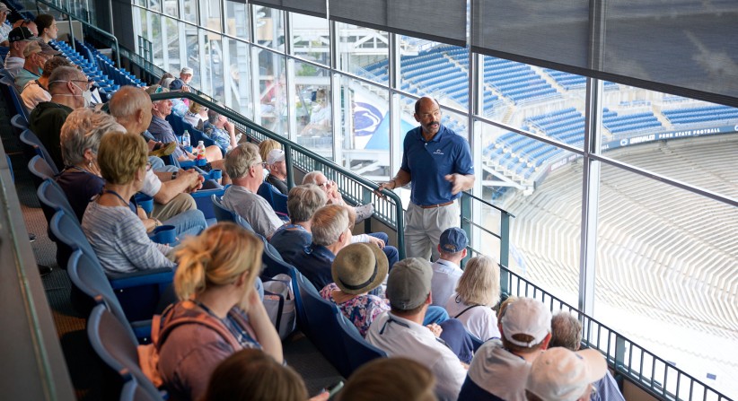photo of Bobby White in stadium suite talking to alums by Penn State Alumni Associatino