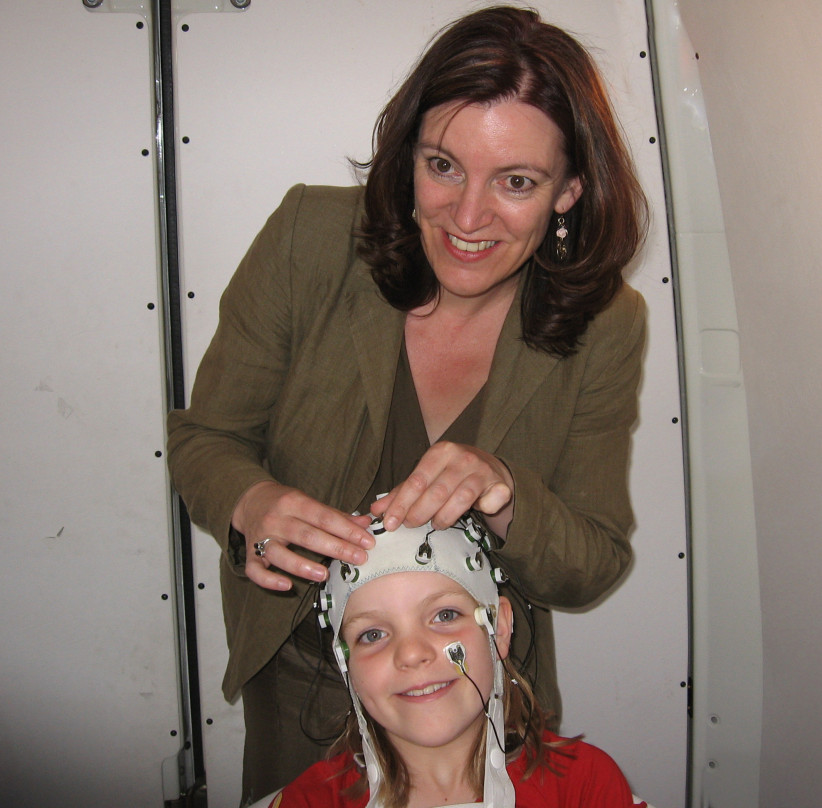 Van Hell attaching electrodes to a child's head, photo courtesy