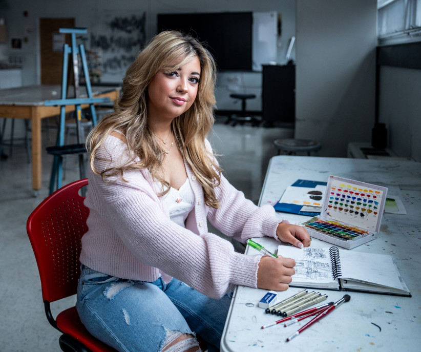 photo of Brinkman seated at a table with art supplies by Cardoni