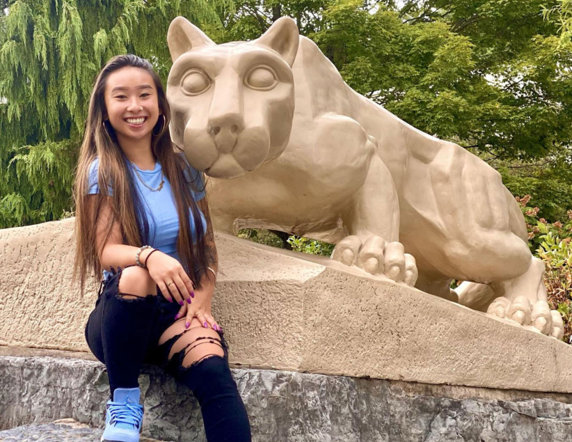 photo of Yu sitting with the Lion Shrine, courtesy