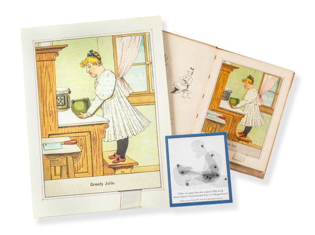 Closeup photo of several pages from an 1890 child's popup book by Lothar Meggendorfer called Greedy Julia. One shows a blonde girl in a white dress standing on a stool with a green honey pot in a kitchen and bears the book's title. Photo by Nick Sloff '92 A&A.
