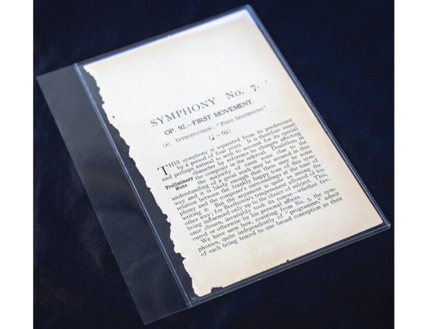 Closeup photo of a piece of paper with the title "Symphony No. 7" preserved between two sheets of polyester film, by Nick Sloff '92 A&A.