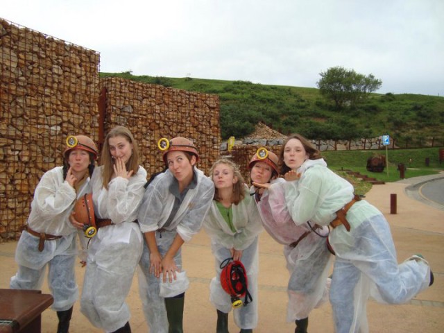 group of women in caving attire blowing kisses to camera, photo by Zena Cardman