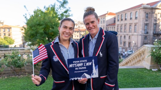 Naeher and Coffey in blue Olympics blazers holding an American flag and a sign that reads Penn State Nittany Lion in Paris, photo by Brad Smith/ISI/Getty Images