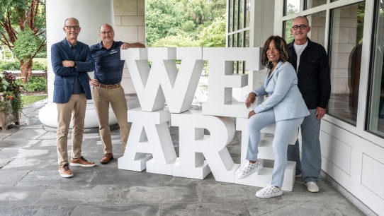 photo of alumni guests on The CMO Podcast posing with large white We Are letters during ALC 2025, photo by Penn State Alumni Association