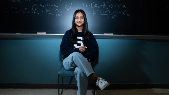photo of Divya Tyago seated in front of a chalkboard by Cardoni