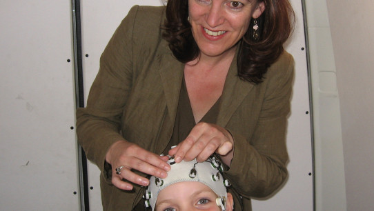 Van Hell attaching electrodes to a child's head, photo courtesy