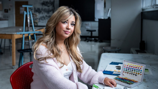 photo of Brinkman seated at a table with art supplies by Cardoni