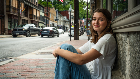photo of Conrad seated on sidewalk leaning against a building by Cardoni
