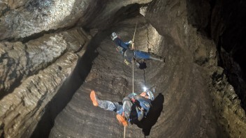 Cavers rappelling down a hole