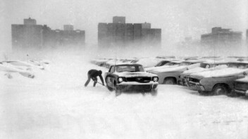 Parking lot 80 and cars covered in snow with a person struggling to get to their car, courtesy Penn State Archives