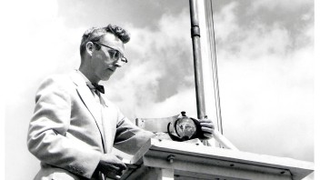 black and white photo of Charles Hosler standing below sunshine recorder by Penn State Archives