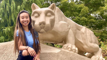 photo of Yu sitting with the Lion Shrine, courtesy