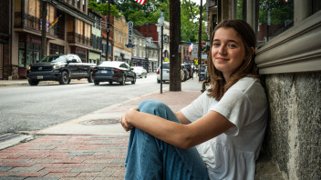 photo of Conrad seated on sidewalk leaning against a building by Cardoni